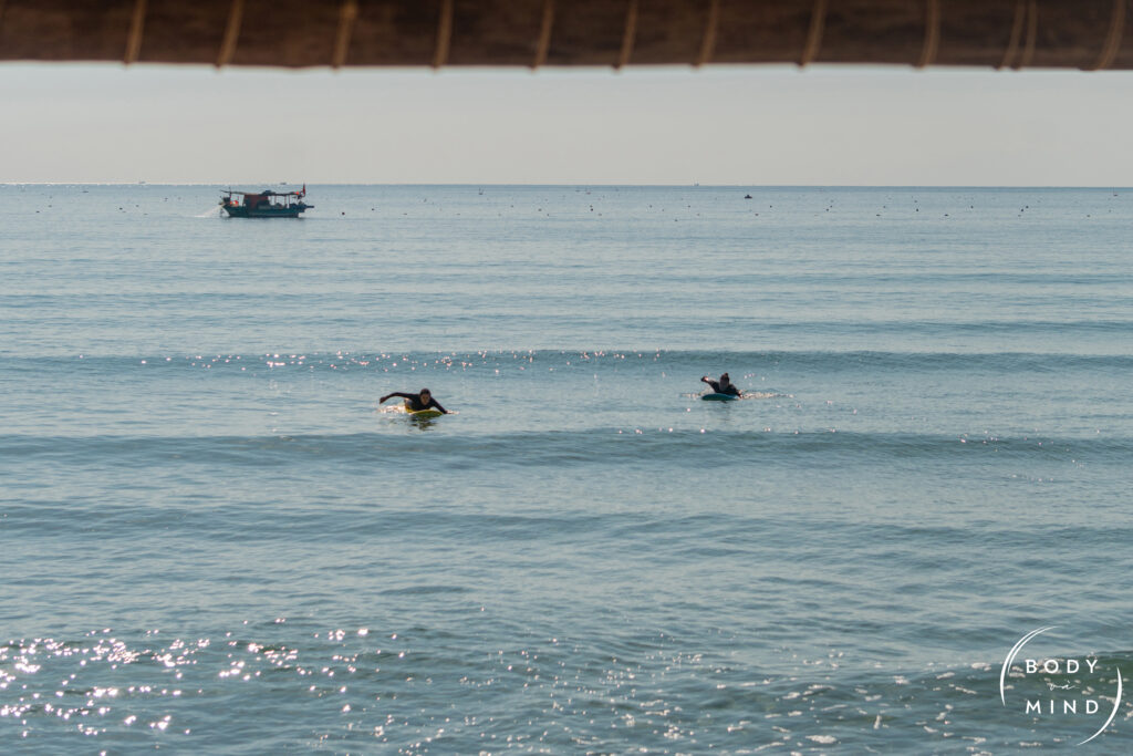 two surfers paddling into a wave in nha trang cam ranh