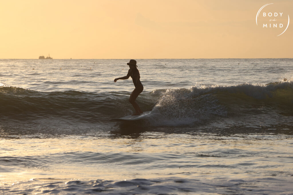 sunrise surf girl catching waves at bodyvamind surf camp yoga and art retreat vietnam nha trang