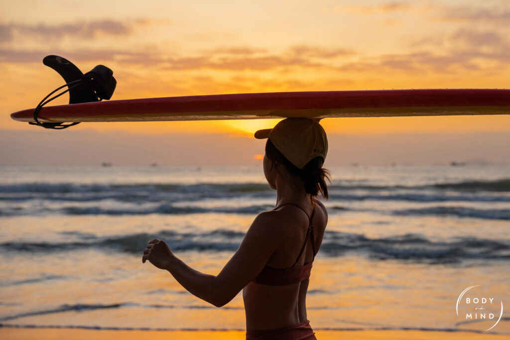 Surfer at sunrise in Cam Lâm, Nha Trang, Vietnam